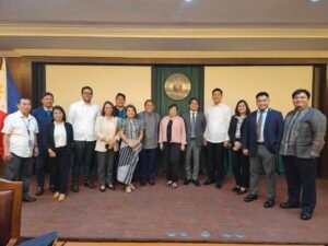 A delegation of professionals and government officials posing for a group photo at the House of Representatives of the Philippines.